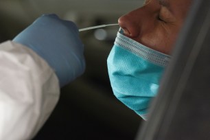 A medical worker administers a test for the coronavirus disease at a Houston-area hospital.
