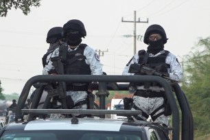 Members of the Mexico's National Guard patrol a road after assailants killed 15 inhabitants of an indigenous village