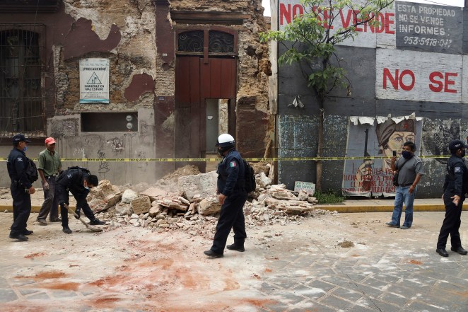 A policeman removes rubble from a building damaged by the earthquake in Oaxaca