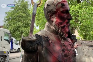 A damaged statue of former Belgian King Leopold II is seen being removed for possible renovation in Ekeren, Belgium.