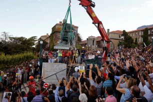Cheering students surround a statue of British colonialist Cecil Rhodes, as it is removed from the campus at the Cape Town University, Cape Town, South Africa.
