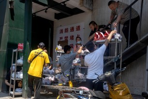 Deliverymen collect food orders in Beijing on Friday, June 19, 2020.