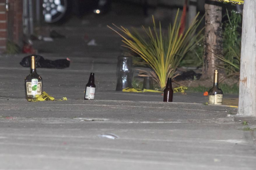 Police use bottles to mark where shell casing are at the scene of 4 people shot near 512 Bristol St. in Brownsville, Brooklyn.