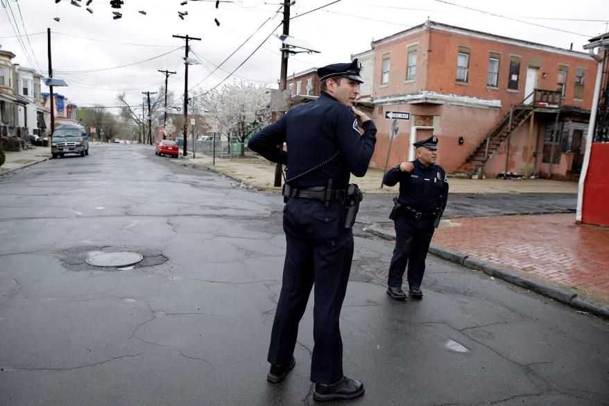 Camden County Metro police officers Lucas Murray (left) and Daniel Torres (right) react to what they thought was a gunshot, as they patrol a neighborhood in Camden, New Jersey.