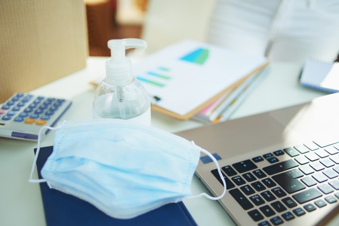 Closeup on medical mask and hand disinfectant.