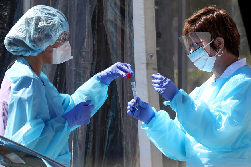 Medical staff secure a sample at a drive-thru coronavirus testing site in San Francisco, California.