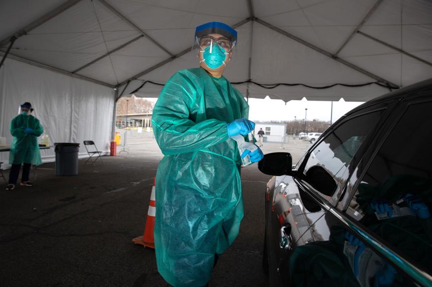 A doctor from SOMOS Community Care prepares to test a patient at a drive-thru coronavirus testing center at Lehman College in the Bronx, New York City.