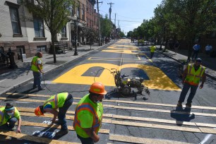 Paint crews from Straight Line Industries from Cohoes, N.Y., work with the city of Albany to paint Black Lives Matter on Lark Street today.