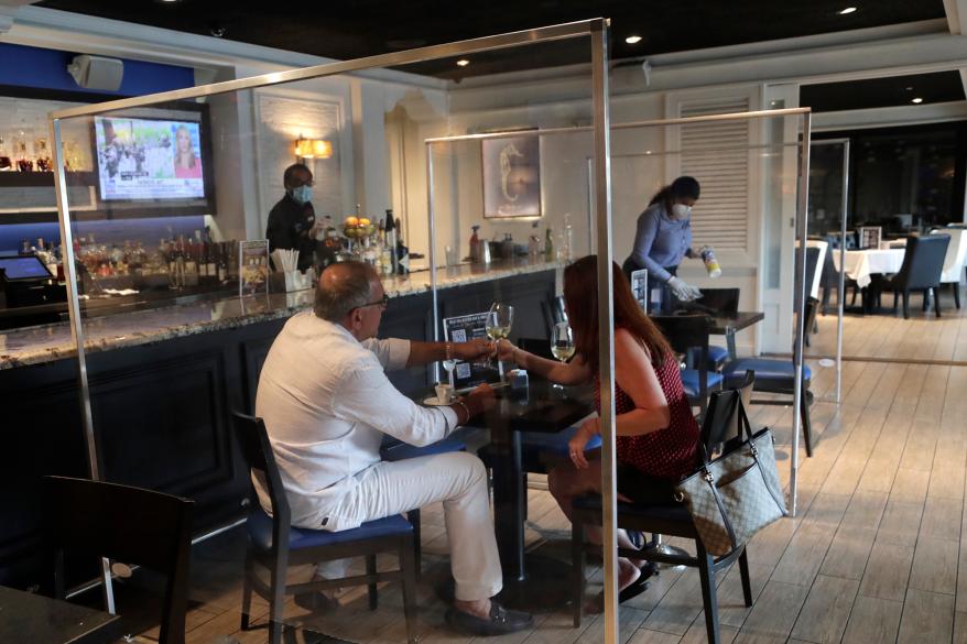 Joseph and Julia Salvaggio, vacationers from Long Island, enjoy a glass of wine at the Wild Sea Oyster Bar and Grille in Fort Lauderdale, Florida.