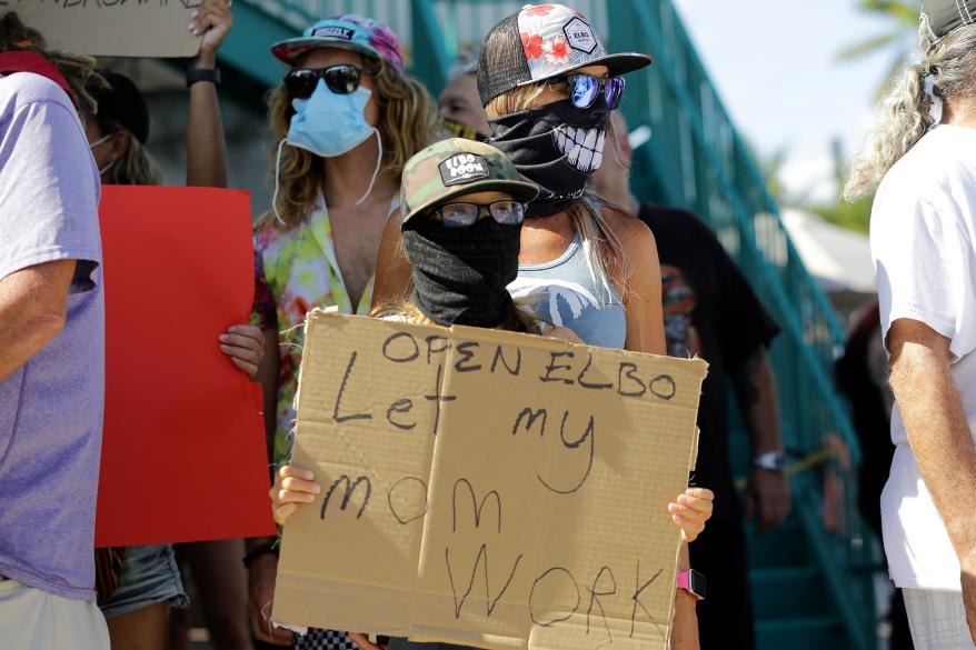 Bartender Kat DeLaTorre stands with her son Nico, 12, during a "Right to Work" rally outside of the Elbo Room bar in Fort Lauderdale, Florida.