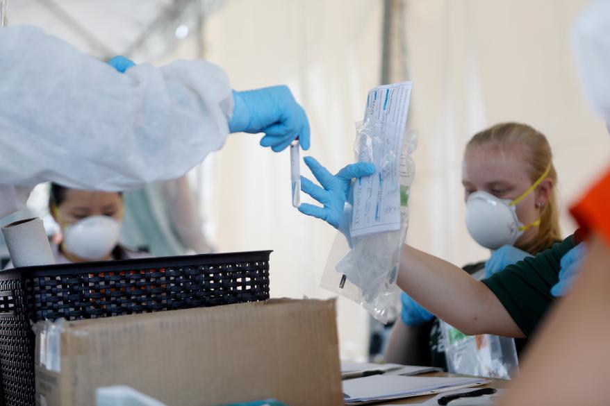 Healthcare worker handle coronavirus testing samples for processing at the Lee Davis Community Resource Center in Tampa, Florida.