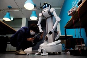 Staff of Mira Robotics changes a part of an Ugo avatar robot at the company's laboratory in Kawasaki, Japan.