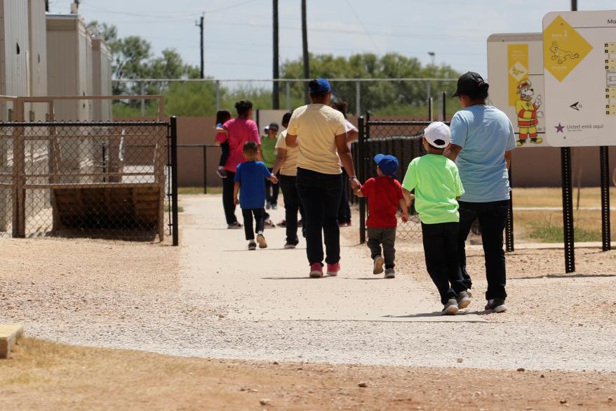 Immigrants seeking asylum hold hands as they leave a cafeteria at the ICE South Texas Family Residential Center in Dilley, Texas.