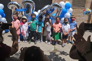 Pre-K students posing for pictures at a graduation ceremony in Jersey City.