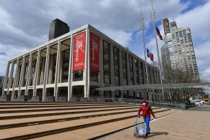 A woman pushes a cart outside Lincoln Center and the New York Philharmonic on April 16, 2020.