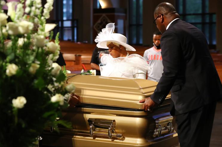 Tomika Miller helps funeral workers close the cover of the casket of her husband, Rayshard Brooks, at the conclusion of his public viewing at Ebenezer Baptist Church