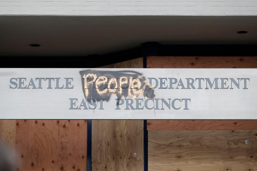 A modified sign for the Seattle Police Department's East Precinct, which had been boarded up and abandoned.