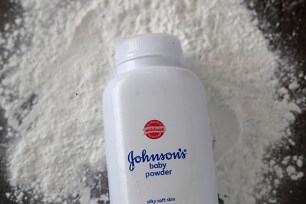 Johnson & Johnson baby powder bottle displayed against a layer of powder