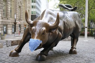 Wall Street bull statue wearing coronavirus mask