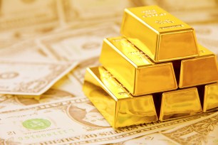 Gold bricks set against a layer of US bills