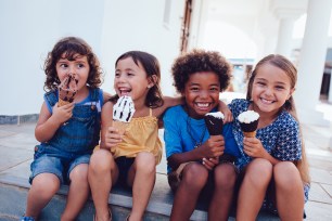 Children eating ice-cream and having fun on summer holidays