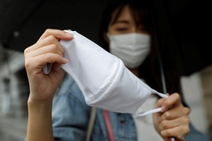 A woman shows Uniqlo's face mask which she bought from Uniqlo's newly launched shop in Tokyo, Japan June 19, 2020.