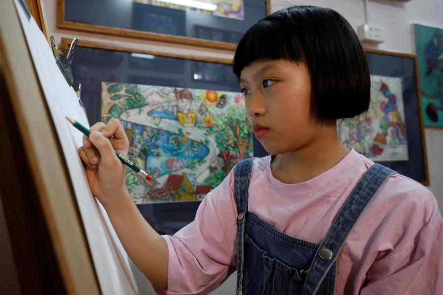 Nguyen Doi Chung Anh, 10, a Vietnamese school girl draws a painting about the coronavirus disease (COVID-19) at her home in Hanoi, Vietnam.