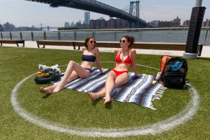 People enjoy the sunny weather in Domino Park in Brooklyn.