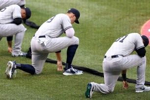 Aaron Judge (center) and other Yankees kneel before the national anthem before Thursday night's game against the Nationals.