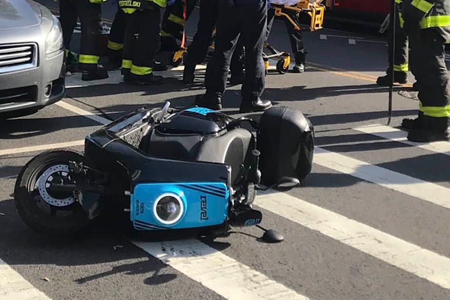 Firefighters work at the scene of a fatal Revel scooter accident