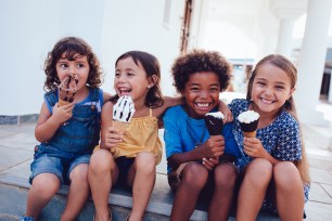 Children laughing and eating ice cream together.