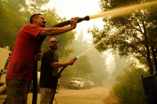 Civilian volunteers Brian Alvarez, left, and Nate Bramwell fight the CZU Lightning Complex Fire in Bonny Doon, California.
