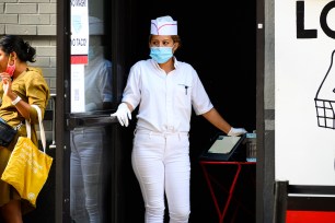 A restaurant worker wears a face mask and rubber gloves in New York City.