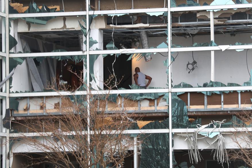 A person walks through a building with its windows blown out after Hurricane Laura.