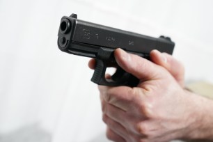 A general view of a man pointing a Glock 19 pistol handgun