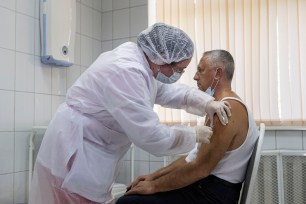 A Russian medical worker adminsters a shot of Russia's experimental Sputnik V coronavirus vaccine