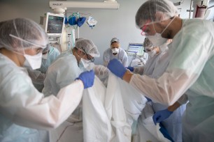 Medical workers tend to a patient suffering from COVID-19 in the Nouvel Hospital Civil of Strasbourg, eastern France.