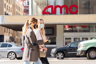 People wear face masks outside of AMC Village 7 movie theater