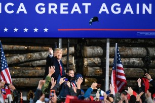 President Donald J. Trump tosses hats to supporters as he arrives for a 'Make America Great Again' election campaign rally at Duluth International Airport