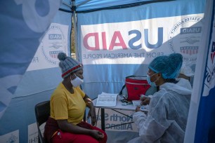 Nurse Nomautanda Siduna, right, talks to a patient who is HIV-positive inside a gazebo used as a mobile clinic in Ngodwana, South Africa.