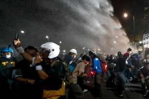 Police use water cannons to disperse pro-democracy protesters during a street march in Bangkok, Thailand.