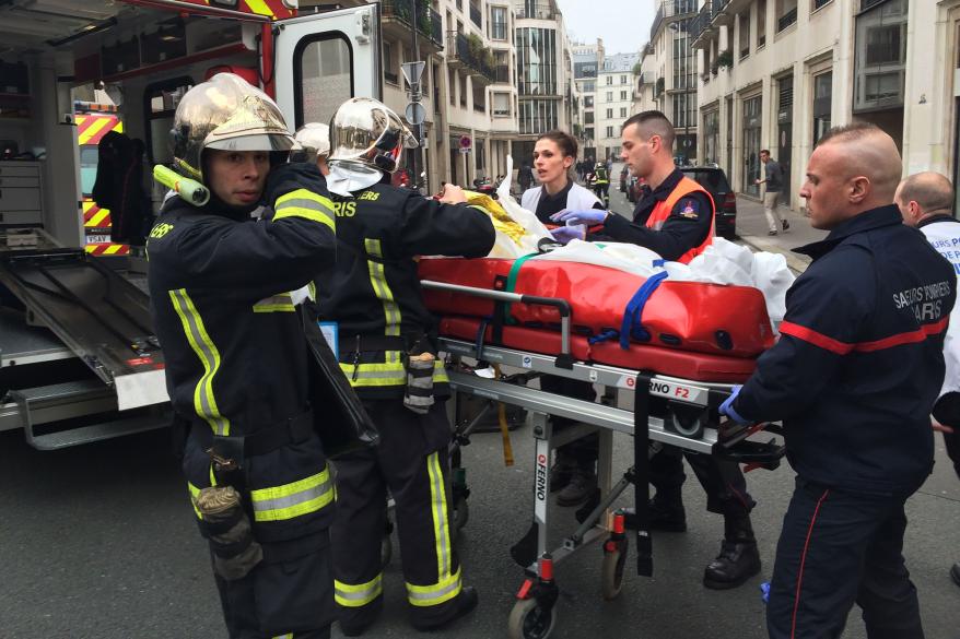 Firefighters carry an injured man on a stretcher in front of the offices of the French satirical newspaper Charlie Hebdo in Paris.