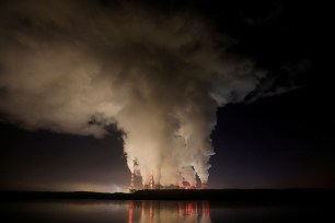 Smoke and steam billow from Belchatow Power Station, Europe's largest coal-fired power plant, operated by PGE Group, at night near Belchatow, Poland.