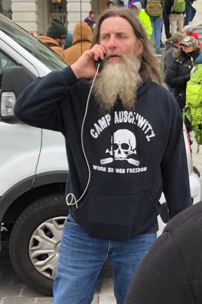 A rioter wearing a sweatshirt with “Camp Auschwitz” stands among the mob of Trump supporters that overran the Capitol building.