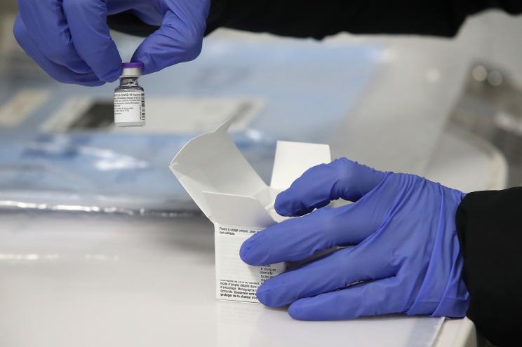 In an cooler, the first doses of the Pfizer COVID-19 vaccine are brought into the Pandemic Response tent at Mississauga Hospital to be prepared