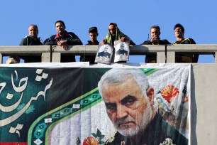 Iranian mourners stand on a bridge during the final stage of funeral processions for slain top general Qasem Soleimani