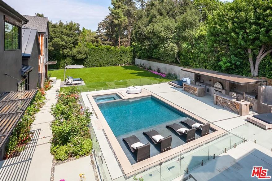 The backyard also has a kitchen with a pizza oven.