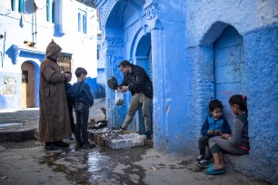 A fishermen sells his catch of the day in an alleyway in Chefchaouen, in northern Morocco, Saturday, Dec. 26, 2020