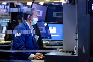 In this photo provided by the New York Stock Exchange, a specialist works at his post on the trading floor