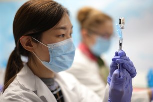 Technicians measure doses of the Pfizer vaccine for COVID-19 at the Virginia Hospital Center in Arlington, Virginia.